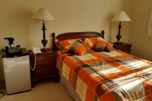 a bedroom with a bed and two lamps and a phone at Puerta del Mar Cozumel in Banco Playa