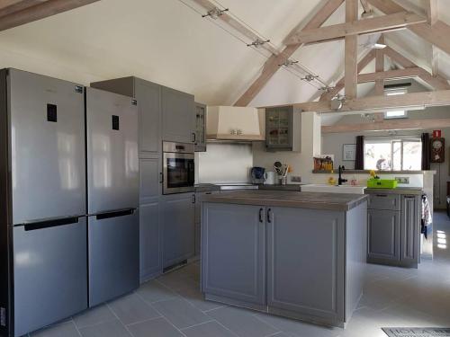 a large kitchen with white appliances and gray cabinets at DHofstede vakantiewoning in Oudenaarde
