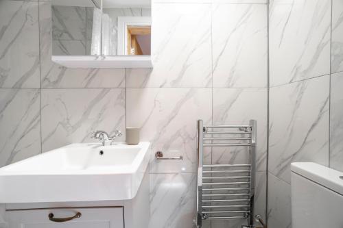 een witte badkamer met een wastafel en een spiegel bij Brand new 1Bed Apt - ZONE 1 - 4 Stations Nearby in Londen