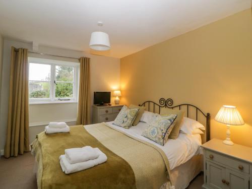 a bedroom with a bed with two towels on it at Crannacombe Farmhouse in Kingsbridge