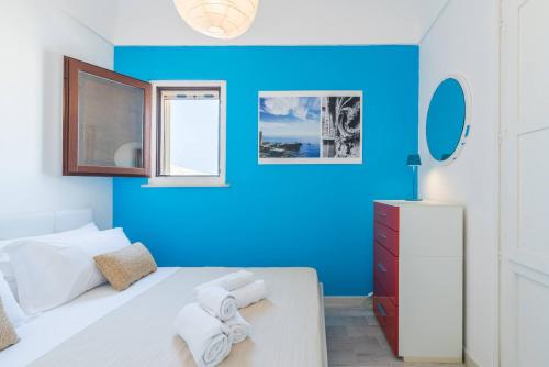 シラクーサにあるAsteria by Dimore in Sicilyの青い壁のベッドルーム1室、ベッド1台(タオル付)