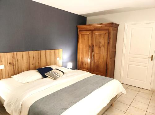 a bedroom with a large bed with a wooden headboard at La Minoterie in Tessy-sur-Vire