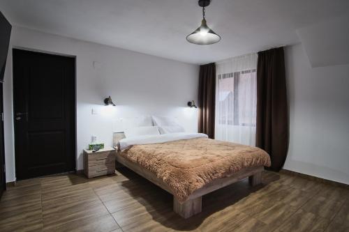 a bedroom with a large bed and a window at Casa cu Tihna in Fundu Moldovei