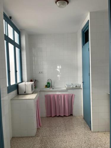 a white kitchen with a sink and a window at Bonito apartamento céntrico cerca de Sevilla in Alcalá de Guadaira