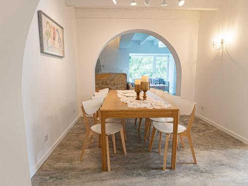 a dining room with a wooden table and chairs at Casa Som do Rio in Ponte de Lima
