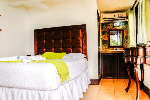 een slaapkamer met een groot bed en een wastafel bij Hotel Mi Paraíso Río Dulce in San Felipe