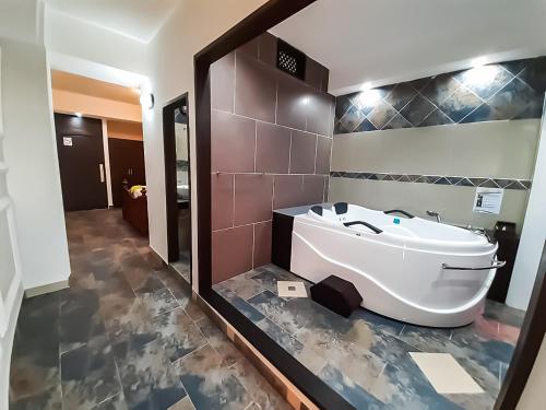 La salle de bains est pourvue d'une baignoire, de toilettes et d'un miroir. dans l'établissement Hotel Mi Paraíso Río Dulce, à San Felipe