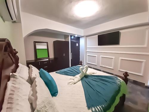 a bedroom with two beds and a tv on the wall at Hotel Mi Paraíso Río Dulce in Castillo de San Felipe