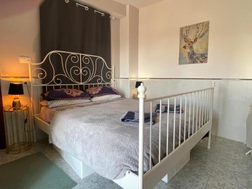 ein Schlafzimmer mit einem Bett mit einem weißen Kinderbett in der Unterkunft The hidden Place in Alcaudete