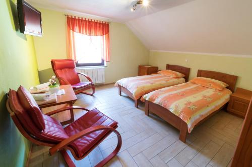 a bedroom with two beds and a table and chairs at Okrepčevalnica Kurn'k in Cerkno
