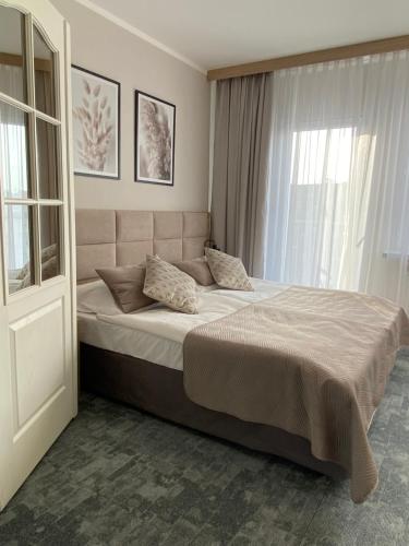 ein Schlafzimmer mit einem großen Bett und einem Fenster in der Unterkunft Apartament Senator 115m2 in Kattowitz