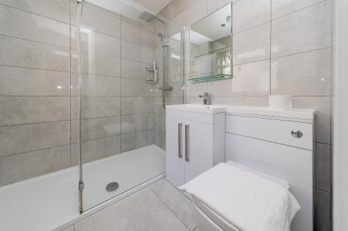 a white bathroom with a shower and a sink at Big House Next to Brighton Beach Sleep 16 I HENS PARTY & STAG DOS WELCOME in Brighton & Hove