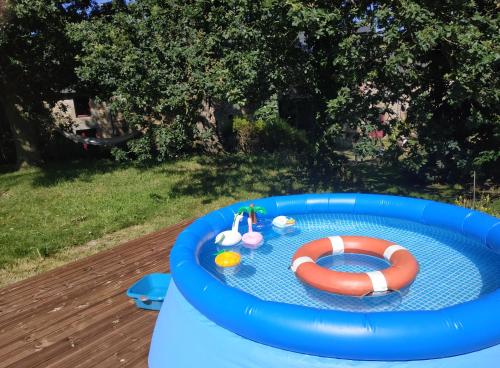 uma piscina insuflável com um salva-vidas e um salva-vidas em La maison à Jean em Val Couesnon