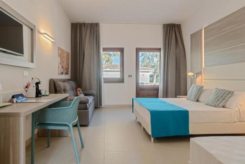 ein Hotelzimmer mit einem Bett, einem Schreibtisch und einem Sofa in der Unterkunft Nicolaus Club Bagamoyo Resort in Cassano Jonio