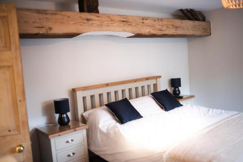 a bedroom with two beds with black pillows on them at Howgill House Barn in Draughton