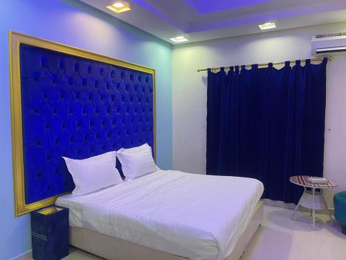 a bedroom with a large bed with a blue headboard at Golden Quba 1 in Riyadh