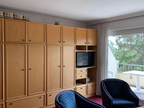 een woonkamer met houten kasten en een televisie bij Haus-Atlantis-Whg-06 in Sankt Peter-Ording