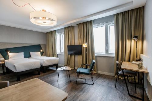 um quarto de hotel com uma cama e uma mesa em Adagio Kyiv Beresteiska em Kiev