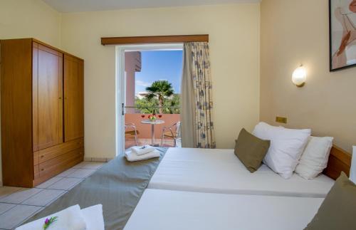 a bedroom with a large bed and a balcony at Dias Hotel Apartments in Agia Marina Nea Kydonias