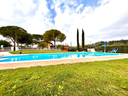a large swimming pool in a park with a grass field at I Girasoli di Lari - Appartamento Indipendente 2 camere da letto in Ripoli