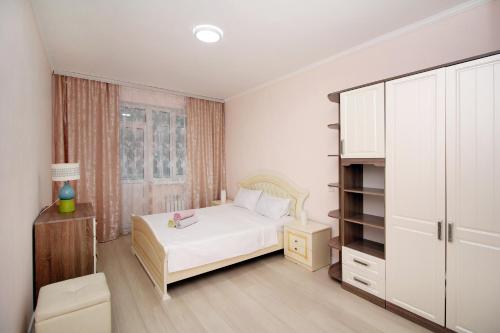 1 dormitorio con cama blanca y ventana en ЖК Верный, 3-комнатная квартира, рядом с верхней Мегой, вдоль речки, en Almaty