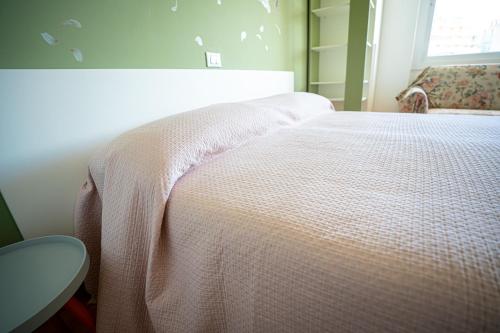 a bedroom with a bed with a white blanket at MICKY HOUSE in Sanremo