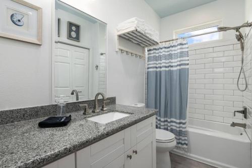 ein Badezimmer mit Waschbecken, Toilette und Dusche in der Unterkunft Gulf Front - Mini Golf - Hot Tub - Family Friendly - ForeShore in Bolivar Peninsula