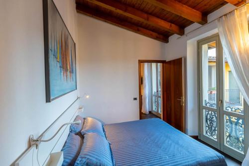 a bedroom with a blue bed and a window at La casa di Fiò in Bergamo