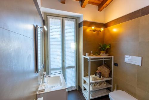 a bathroom with a sink and a toilet and a window at La casa di Fiò in Bergamo