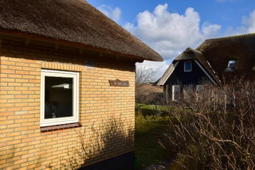 athatch überdachtes Haus mit einem Fenster im Hof in der Unterkunft in het Dal in Buren