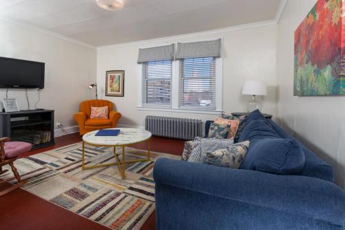 uma sala de estar com um sofá azul e uma mesa em The Jazz Suite B1 em Hartford