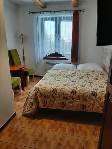 a bedroom with a bed and a window at Kazkowa Koliba in Zakopane
