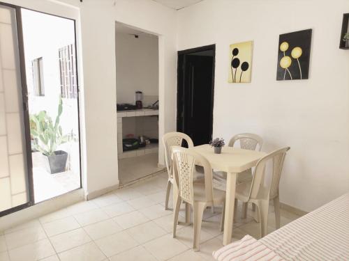 a white dining room with a table and chairs at Apartamentos Villa Leonor in Coveñas