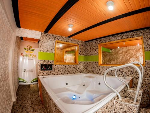 Cette chambre comprend une salle de bains pourvue d'une grande baignoire. dans l'établissement Savieza Life Experience, à Nemocón