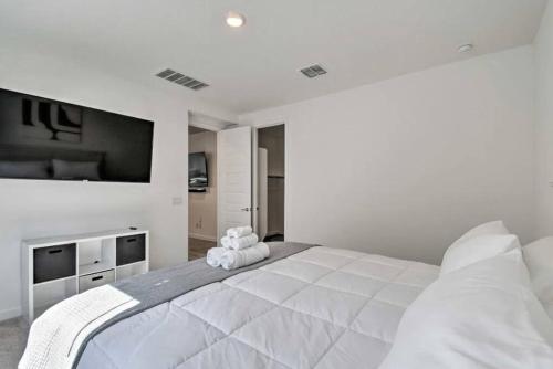 ein weißes Schlafzimmer mit einem großen Bett und einem Flachbild-TV in der Unterkunft Super Bowl Ready Brand New House in Litchfield Park
