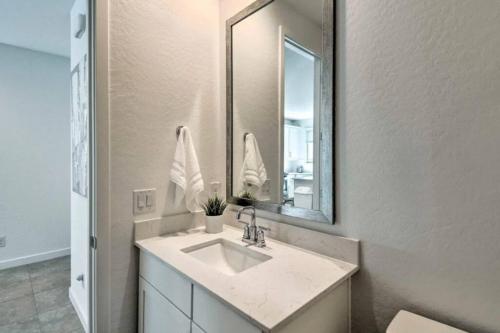 ein Bad mit einem Waschbecken und einem Spiegel in der Unterkunft Super Bowl Ready Brand New House in Litchfield Park