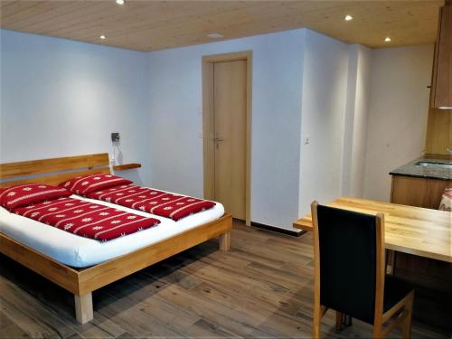 Un dormitorio con una cama con almohadas rojas. en "Studio Edelweiss" Spillstatthus, en Grindelwald