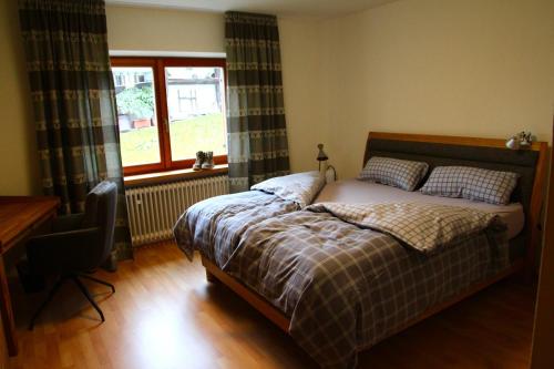 a bedroom with a bed and a desk and a window at Bergsonne in Reit im Winkl