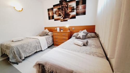 um quarto com 2 camas e uma cómoda em Apartamentos Montblanc Familidays 013 em Salou