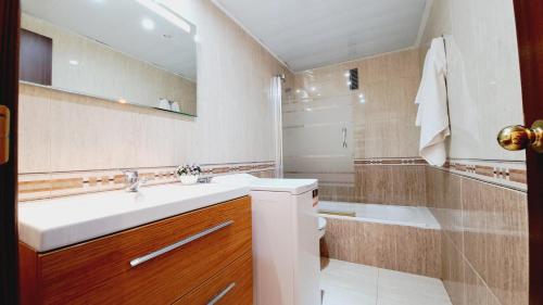 uma casa de banho com um lavatório, um WC e uma banheira em Apartamentos Montblanc Familidays 013 em Salou