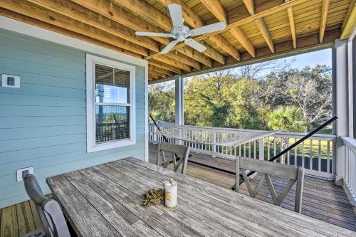 a porch with a table and chairs and a ceiling fan at 3 Decks and Water Views Breezy Home in Hilton Head in Hilton Head Island