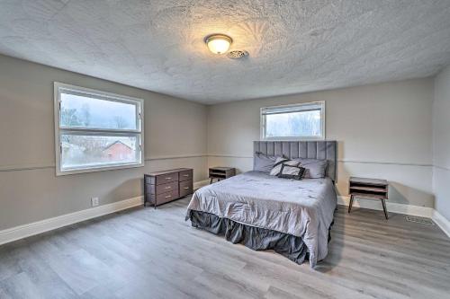 um quarto com uma cama e duas janelas em Whitesburg Vacation Home with Screened Porch em Whitesburg