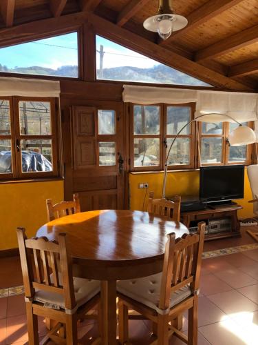 ein Esszimmer mit einem Holztisch und Stühlen in der Unterkunft Casa Laudina y Armando in Brañella
