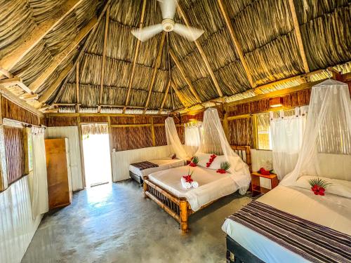 a bedroom with two beds and a ceiling at Playa Bonita Hotel EcoCabañas Tayrona in Buritaca