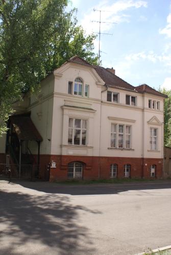 a large brick building with windows on a street at Pension Markgrafenmühle in Cottbus
