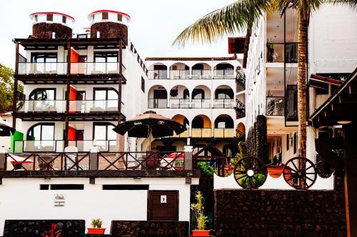 a white building with a balcony with an umbrella at Hotel Mi Paraíso Río Dulce in Castillo de San Felipe