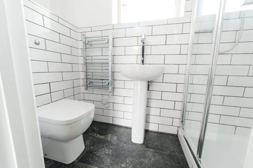 een witte badkamer met een toilet en een wastafel bij Delores Eco-Pod / Treehouse, Walk to Cabot Circus in Bristol