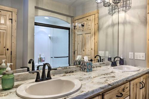 a bathroom with two sinks and a large mirror at Lakefront Cottage in Iron River with 2 Porches! in Iron River
