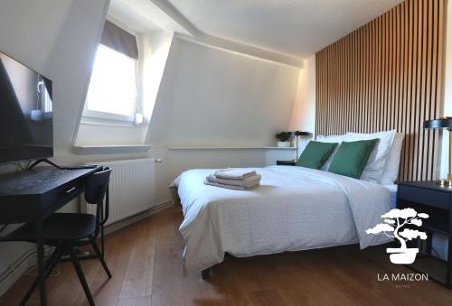 a bedroom with a bed and a desk and a television at Suite dernier étage Saint-Maur in La Madeleine