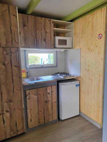 a small kitchen with a sink and a refrigerator at Camping Costa Blanca in El Campello